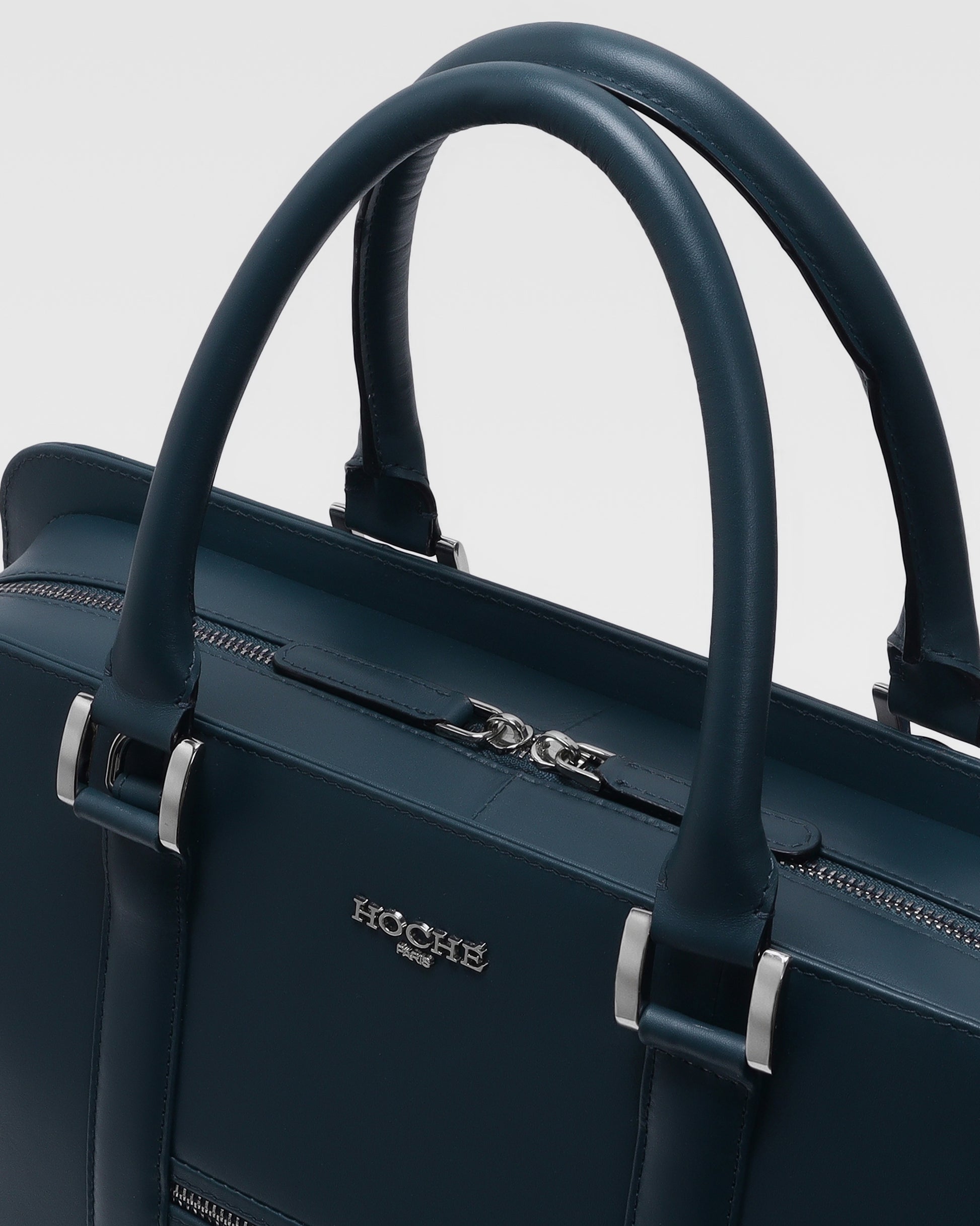 Close-up of PinnaclePro dark blue leather laptop bag for men, highlighting the rich leather texture, precision stitching, and custom metal hardware.
