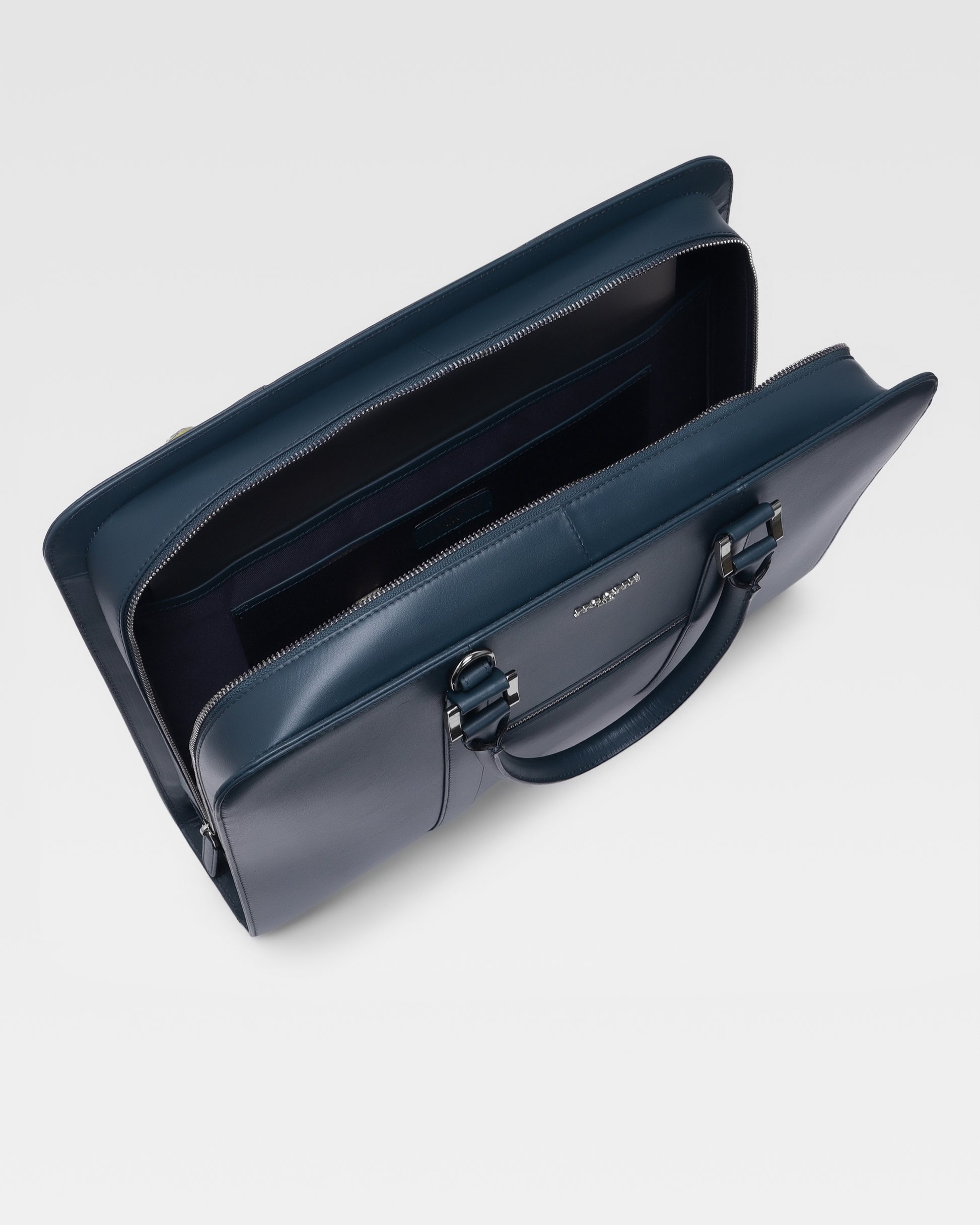 Open view of PinnaclePro dark blue leather laptop bag for men, displaying a spacious interior with a padded laptop compartment and multiple organizers