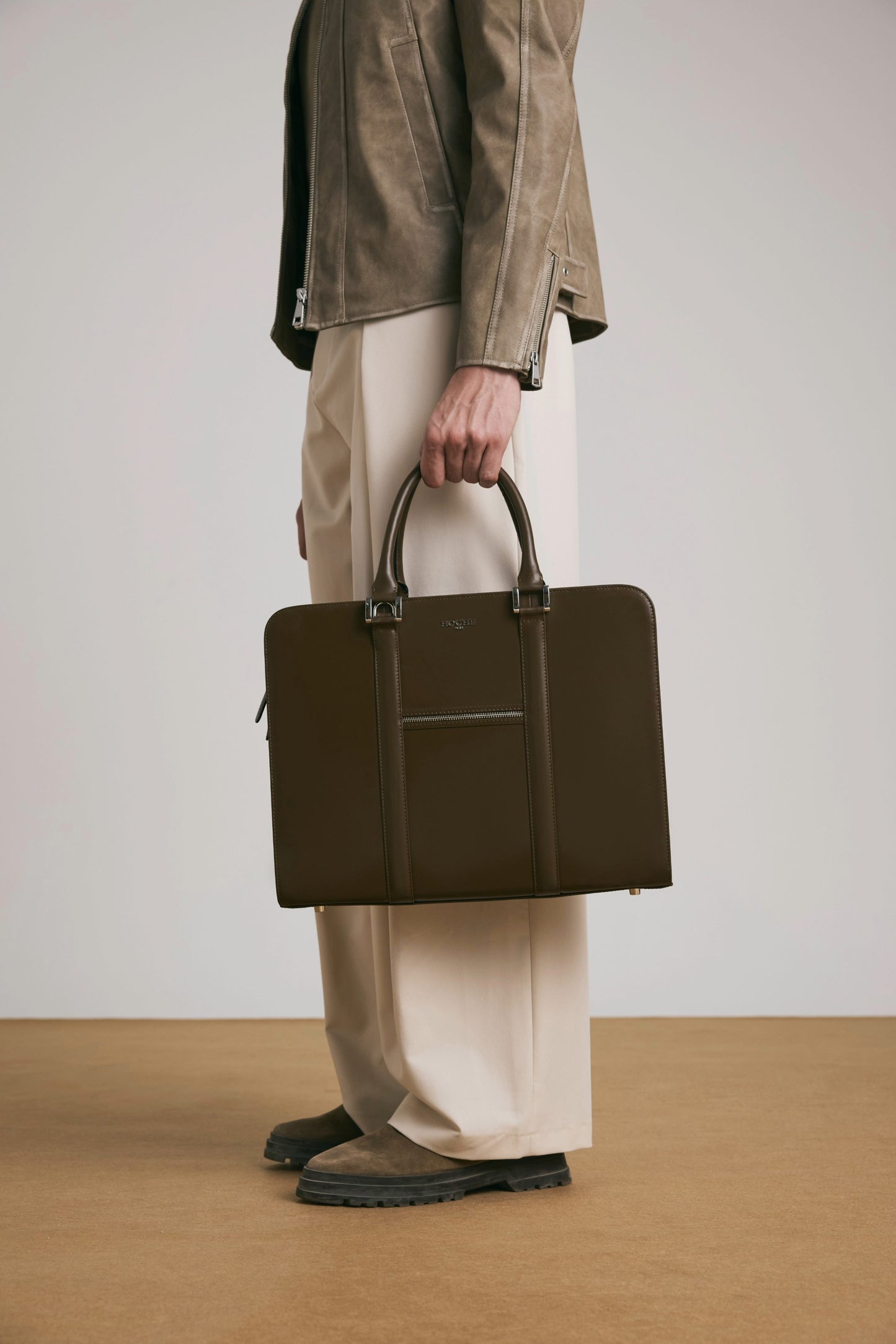 Luxury lifestyle shot of PinnaclePro dark brown branded leather laptop bag for men in Inida, complementing a sophisticated and professional look.
