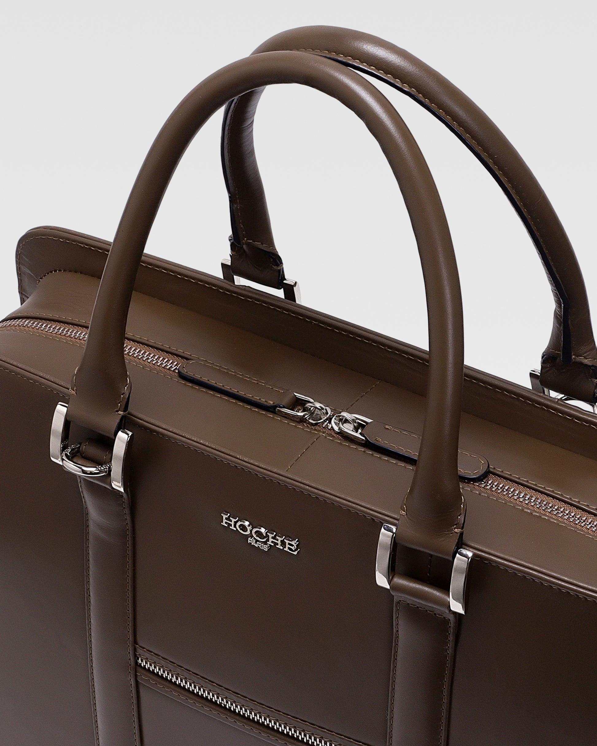 Close-up of PinnaclePro dark brown branded leather laptop bag for men, highlighting premium leather texture, elegant stitching, and custom metal hardware.