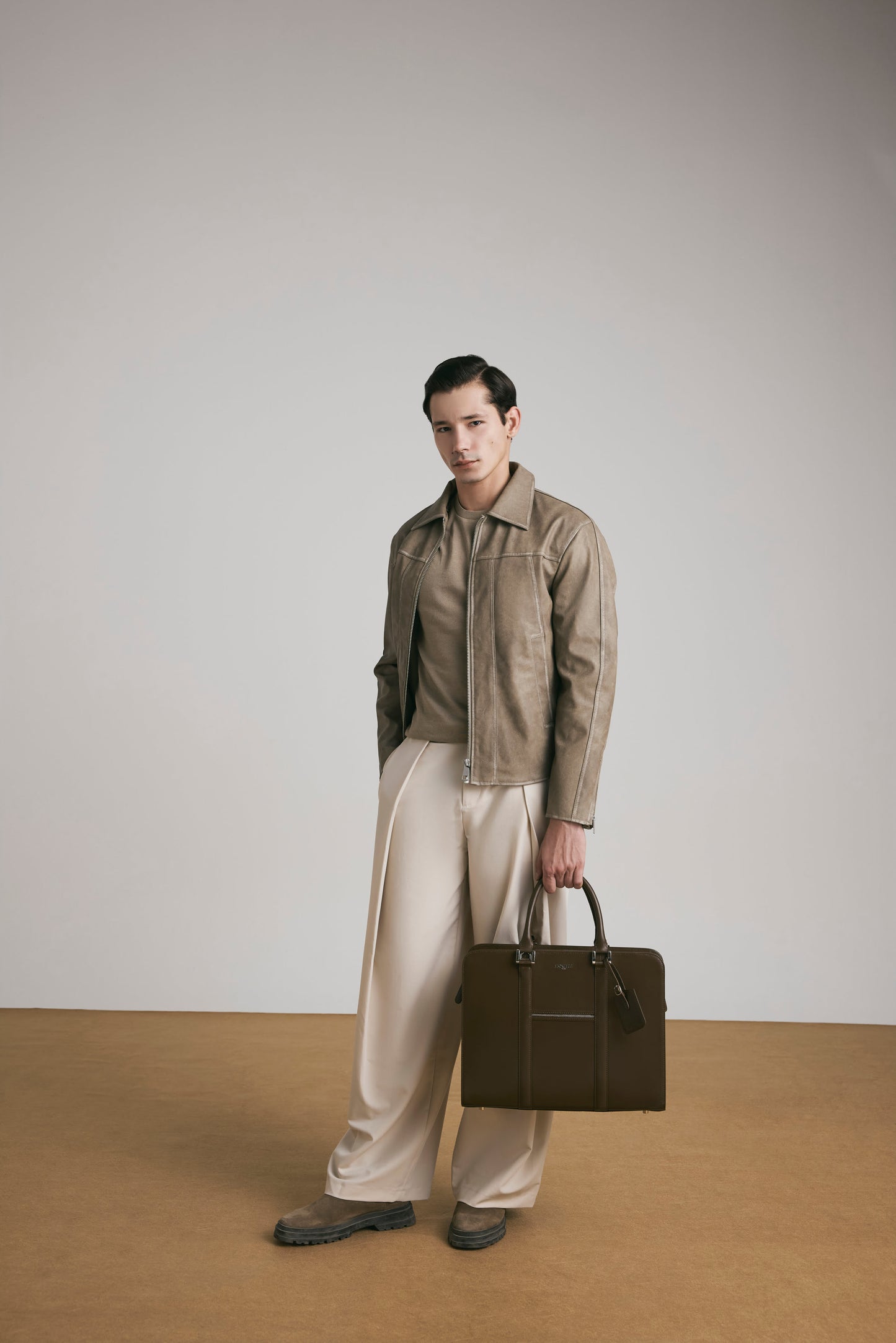 Luxury lifestyle shot of PinnaclePro dark brown branded leather laptop bag for men, complementing a sophisticated and professional look.