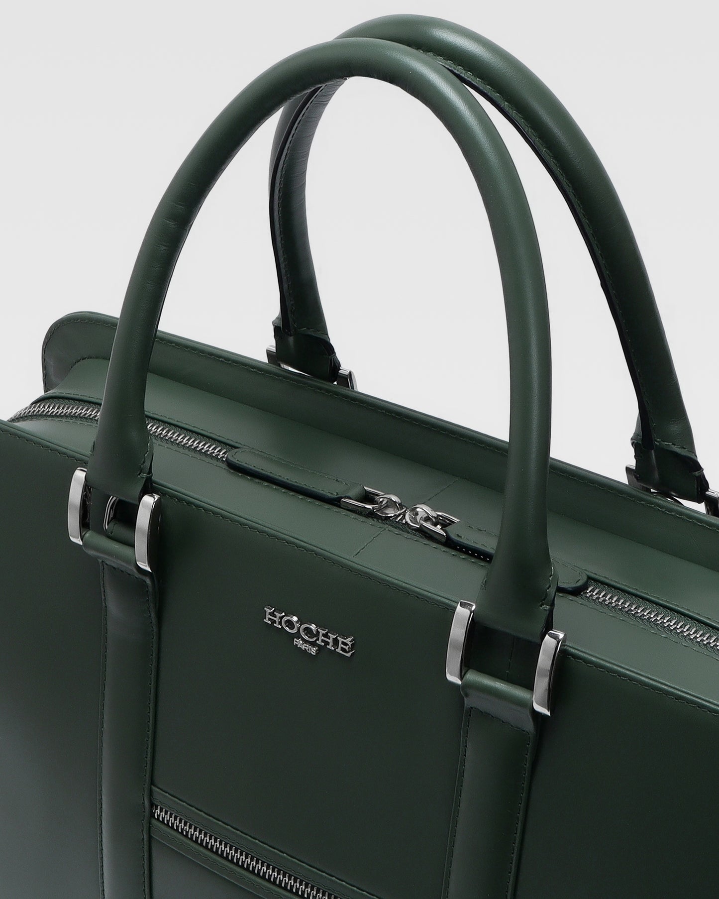 Close-up of PinnaclePro olive green genuine leather laptop bag, highlighting rich leather texture, precision stitching, and custom metal hardware