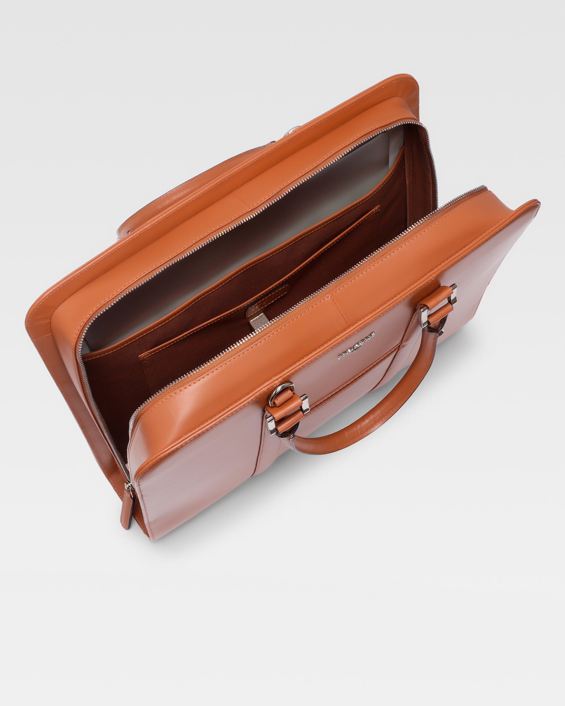 Open view of PinnaclePro Umber Tan genuine leather laptop bag for men in India, displaying a spacious interior, padded laptop compartment, and multiple organizer pockets.