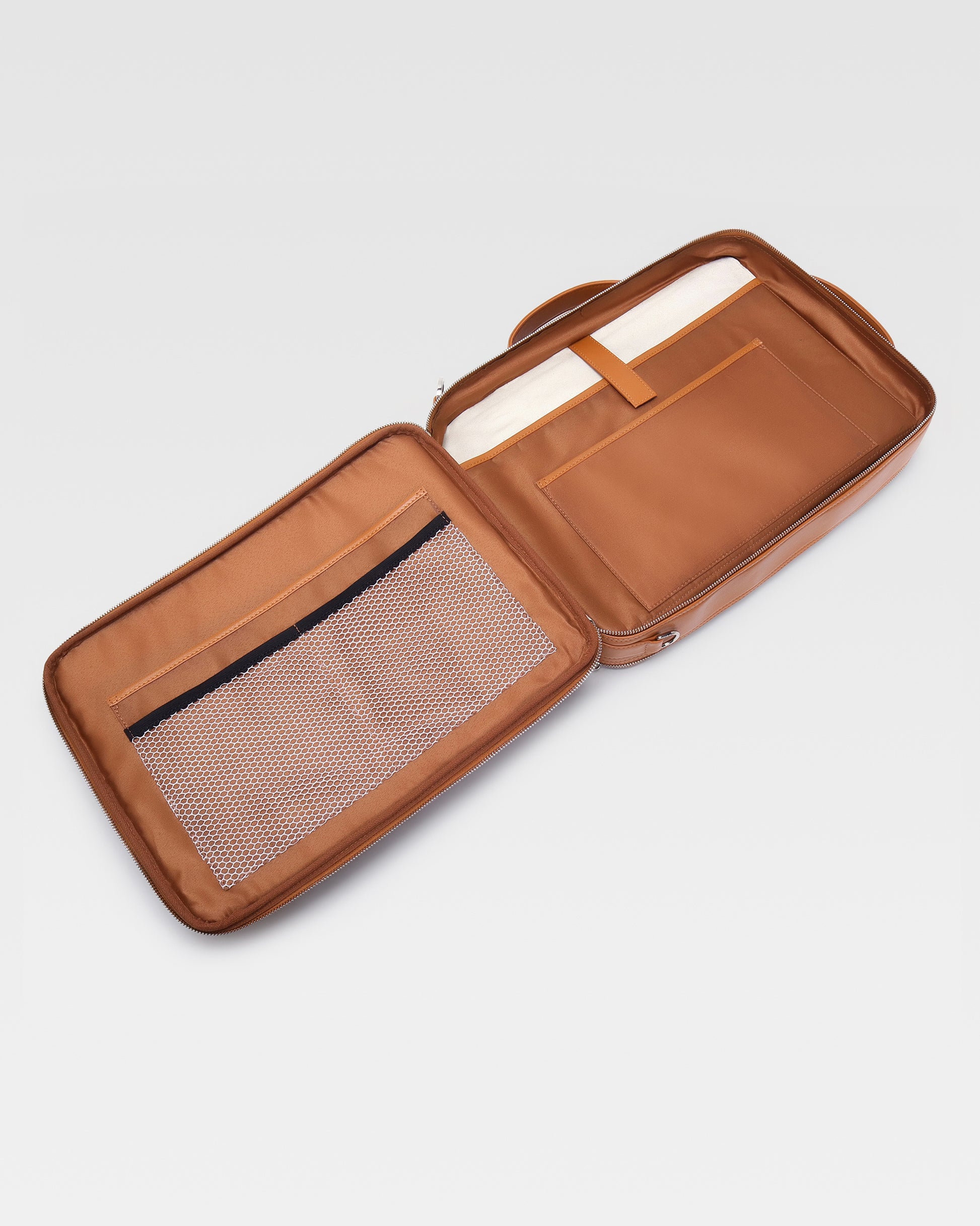 Open view of UniSwitch tan branded genuine leather backpack for men in India, showcasing spacious compartments, a padded laptop sleeve, and secure storage